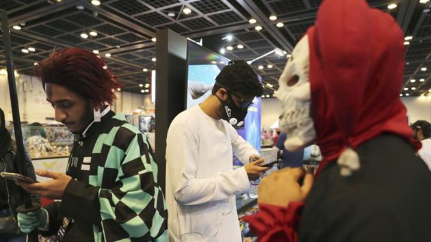 A man watches his mobile phone while wearing a face mask at the Middle East Comic Con in Dubai, United Arab Emirates, Thursday, March 5, 2020. The Middle East Film & Comic Con has begun in Dubai, a city of skyscrapers and nightclubs suddenly subdued by the outbreak of the new coronavirus across the region. (AP Photo/Kamran Jebreili) (AP)