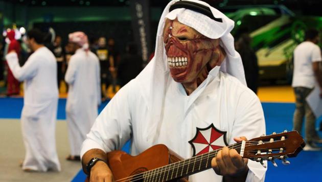 An Emirati dressed as Nemesis from the "Resident Evil" video game series plays a guitar at the Middle East Film & Comic Con in Dubai, United Arab Emirates, Thursday, March 5, 2020. The Middle East Film & Comic Con began Thursday night in Dubai, a city of skyscrapers and nightclubs suddenly subdued by the outbreak of the new coronavirus across the region. (AP Photo/Jon Gambrell) (AP)