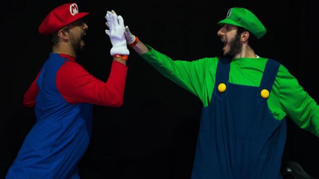 Bibi Zumot of Jordan, left, dressed as Mario, and Mohamed Rashed of Egypt, right, dressed as Luigi, high-five at the Middle East Film & Comic Con in Dubai, United Arab Emirates, Thursday, March 5, 2020. The Middle East Film & Comic Con began Thursday night in Dubai, a city of skyscrapers and nightclubs suddenly subdued by the outbreak of the new coronavirus across the region. (AP Photo/Jon Gambrell) (AP)