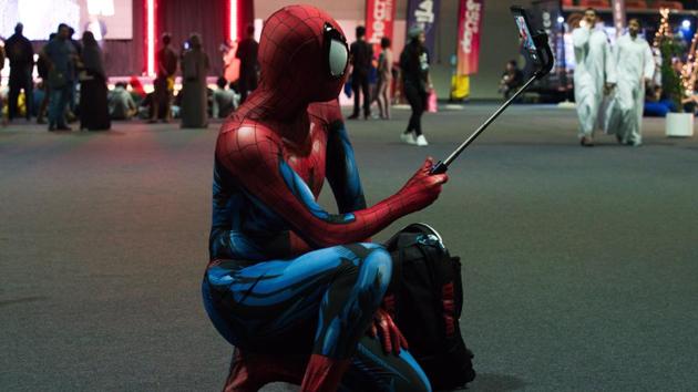 A man dressed as Spiderman pauses for a selfie at the Middle East Film & Comic Con in Dubai, United Arab Emirates, Thursday, March 5, 2020. The Middle East Film & Comic Con began Thursday night in Dubai, a city of skyscrapers and nightclubs suddenly subdued by the outbreak of the new coronavirus across the region. (AP Photo/Jon Gambrell) (AP)