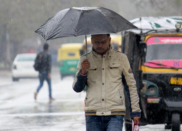 A man back in winterwear amid rain on Saturday(Gurminder SIngh/HT)
