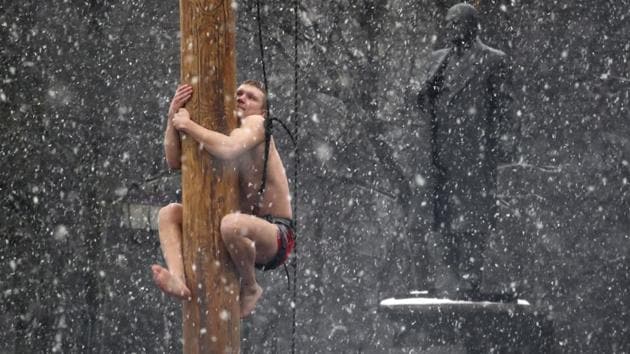 A man climbs on a pole in snowfall to get a prize during celebrations of Maslenitsa, or Pancake Week, in Veliky Novgorod, Russia, some 550 kilometre northeast of Moscow, Russia. Maslenitsa is traditional Russian holiday marking the end of winter that dates back to pagan times. At background right is a statue of Soviet Union founder Vladimir Lenin. (Dmitri Lovetsky / AP) A man climbs on a pole in snowfall to get a prize during celebrations of Maslenitsa, or Pancake Week, in Veliky Novgorod, Russia, some 550 kilometre northeast of Moscow, Russia. Maslenitsa is traditional Russian holiday marking the end of winter that dates back to pagan times. At background right is a statue of Soviet Union founder Vladimir Lenin. (Dmitri Lovetsky / AP)