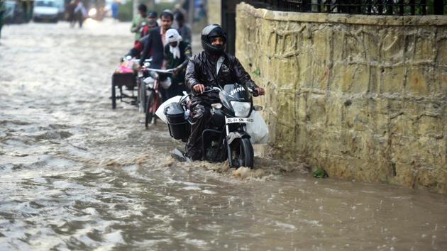Commuters move through a waterlogged near Ramlila Ground in New Delhi. A senior scientist at the India Metrological Department (IMD) said the rainfall recorded was in the ‘moderate’ category (15 mm to 64 mm) and was mainly resulted by an intense western disturbance accompanied with a cyclonic circulation over West Rajasthan. (Raj K Raj / HT Photo) Commuters move through a waterlogged near Ramlila Ground in New Delhi. A senior scientist at the India Metrological Department (IMD) said the rainfall recorded was in the ‘moderate’ category (15 mm to 64 mm) and was mainly resulted by an intense western disturbance accompanied with a cyclonic circulation over West Rajasthan. (Raj K Raj / HT Photo)