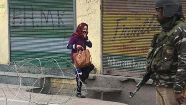 A woman crosses barbed concertina wire as a Paramilitary soldier stands guard during restrictions in Downtown area in Srinagar, Jammu and Kashmir, India, on Tuesday, February 11, 2020.(Photo: Waseem Andrabi / Hindustan Times) A woman crosses barbed concertina wire as a Paramilitary soldier stands guard during restrictions in Downtown area in Srinagar, Jammu and Kashmir, India, on Tuesday, February 11, 2020.(Photo: Waseem Andrabi / Hindustan Times)