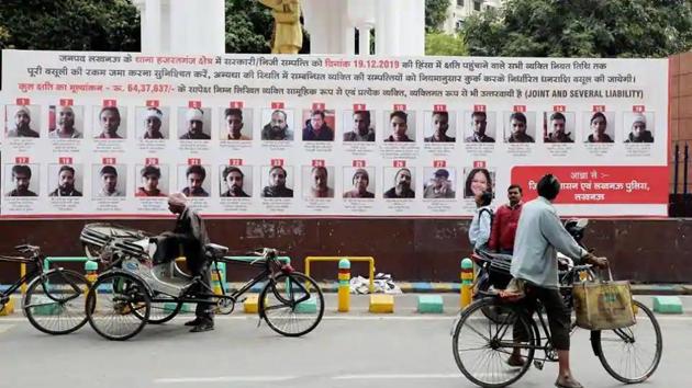 Lucknow administration put up hoardings with photographs, names, and addresses of 57 people who have been issued recovery notice for their alleged involvement in violence during Anti CAA protest in Lucknow on Friday.(ANI Photo)