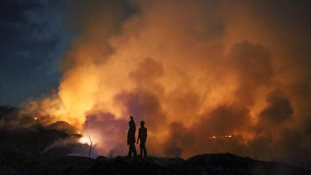 Firefighters are silhouetted as fire breaks out on a heap of garbage and scrap, behind Modi Compound at Bhiwandi, in Thane district of Maharashtra. Even though it took around four hours to extinguish the fire, no one was injured during the incident. (Praful Gangurde / HT Photo) Firefighters are silhouetted as fire breaks out on a heap of garbage and scrap, behind Modi Compound at Bhiwandi, in Thane district of Maharashtra. Even though it took around four hours to extinguish the fire, no one was injured during the incident. (Praful Gangurde / HT Photo)