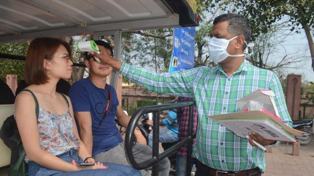 An official uses a thermal screening device on tourists, in wake of the deadly novel coronavirus, at Taj Mahal, in Agra, Thursday, March 5, 2020. (PTI)