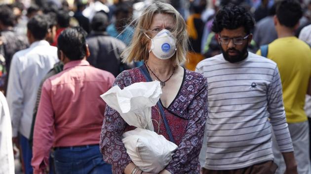 A tourist wearing a protective mask as a precautionary measure following multiple positive cases of coronavirus in New Delhi.(Burhaan Kinu/HT PHOTO)