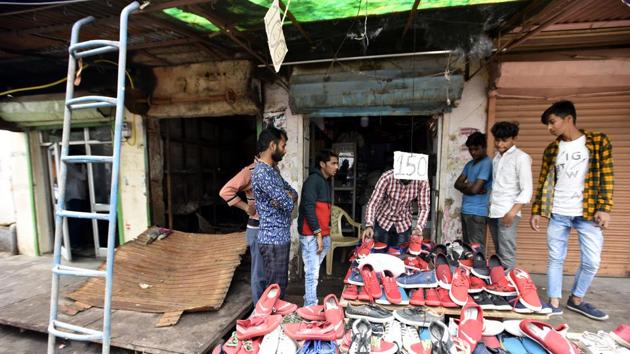A man sells shoes outside his shop burnt partially during last week's violence in north-east Delhi over the Citizenship Amendment Act (CAA), at Chand Bagh, in New Delhi. Two of his shops were burnt last week. One shop was fully burnt, while the other was partially burnt. (Sonu Mehta / HT Photo) A man sells shoes outside his shop burnt partially during last week's violence in north-east Delhi over the Citizenship Amendment Act (CAA), at Chand Bagh, in New Delhi. Two of his shops were burnt last week. One shop was fully burnt, while the other was partially burnt. (Sonu Mehta / HT Photo)