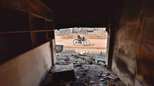 A man cycles outside a burnt shop in a riot-affected area, at Chand Bagh, in New Delhi. (Sanchit Khanna / HT Photo) A man cycles outside a burnt shop in a riot-affected area, at Chand Bagh, in New Delhi. (Sanchit Khanna / HT Photo)