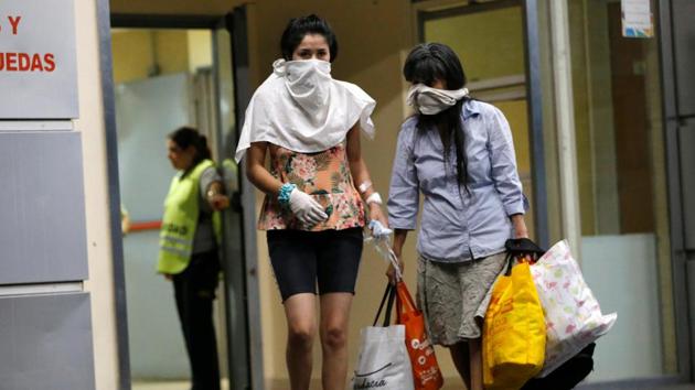 People cover their faces while leaving Hospital Cosme Argerich, after the first fatality from coronavirus in Latin America was confirmed, in Buenos Aires, Argentina. (REUTERS)
