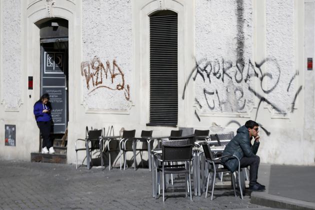 A man sits at a table as others are empty at a cafe in Largo Argentina square amid growing concern about the spread of a new coronavirus in Rome. Italy is taking an almighty hit to its already weak economy from being the focal point of the coronavirus emergency in Europe. (AP) A man sits at a table as others are empty at a cafe in Largo Argentina square amid growing concern about the spread of a new coronavirus in Rome. Italy is taking an almighty hit to its already weak economy from being the focal point of the coronavirus emergency in Europe. (AP)
