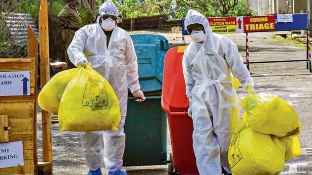 Medical staff, wearing protective suits, dispose of medical waste as they exit the Special Isolation Ward set up to provide treatment to Covid-19 patients at Kochi Medical college in Kerala on February 8. (PTI photo)