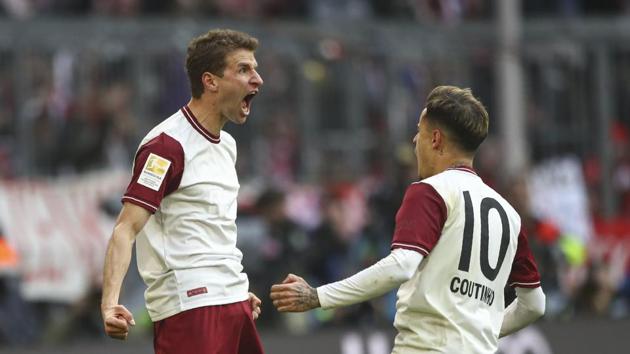 Bayern's Thomas Mueller, left, celebrates with Philippe Coutinho after scoring his side's first goal during the German Bundesliga soccer match between FC Bayern Munich and FC Augsburg in Munich (AP)