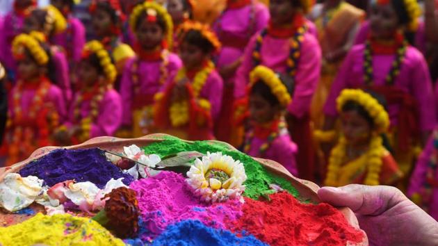 A person holds a tray laden with various coloured powders as students wearing garlands of flowers participate in a cultural procession in Kolkata, West Bengal. (Dibyangshu Sarkar / AFP) A person holds a tray laden with various coloured powders as students wearing garlands of flowers participate in a cultural procession in Kolkata, West Bengal. (Dibyangshu Sarkar / AFP)