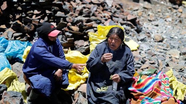 Eva Chura and another pallaquera, smoke and drink anise while chewing coca leaves, as part of a ritual for searching for gold performed before a shift, in La Rinconada. "I don't count my husband, because he is no help as a father or a husband," Chura said. "I'm the papa and the mama. ... We don't want for anything. We have everything." (Nacho Doce / REUTERS) Eva Chura and another pallaquera, smoke and drink anise while chewing coca leaves, as part of a ritual for searching for gold performed before a shift, in La Rinconada. "I don't count my husband, because he is no help as a father or a husband," Chura said. "I'm the papa and the mama. ... We don't want for anything. We have everything." (Nacho Doce / REUTERS)