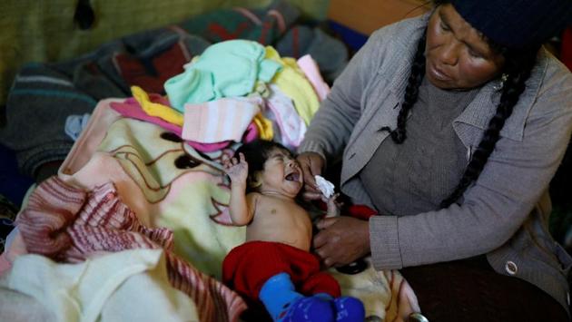 Chura cleans her three-month-old son Alizon in her room. Now, Chura and others in La Rinconada say the gold supply is running out in this area. “It’s not like it used to be. That’s why so many ugly things happen,” she said. Miners have been shot dead in the tunnels; young women are trafficked into brothels; fights are common. (Nacho Doce / REUTERS) Chura cleans her three-month-old son Alizon in her room. Now, Chura and others in La Rinconada say the gold supply is running out in this area. “It’s not like it used to be. That’s why so many ugly things happen,” she said. Miners have been shot dead in the tunnels; young women are trafficked into brothels; fights are common. (Nacho Doce / REUTERS)
