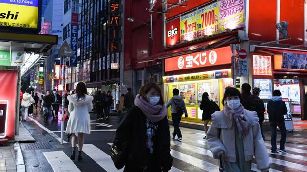 Pedestrians wear protective masks while walking past stores in the Akihabara shopping district of Tokyo, Japan.(Bloomberg)