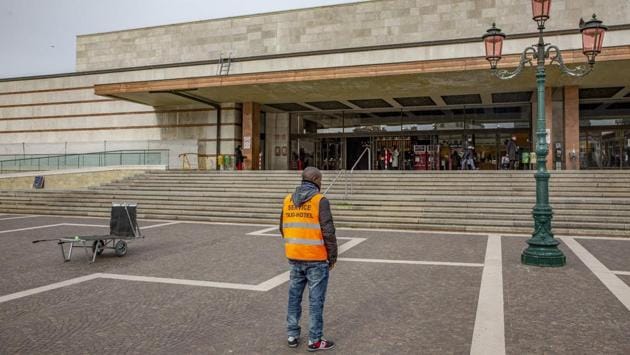 A luggage porter waits for clients at a railway station in Venice. Veneto’s regional president Luca Zaia has been battling to preserve Venice’s tourism industry in the face of the contagion. On Wednesday, he posted a gauzy photo of the lagoon city on his Facebook page with the caption: “Venice ‘infects’ only with its beauty.” (Francesca Volpi / Bloomberg) A luggage porter waits for clients at a railway station in Venice. Veneto’s regional president Luca Zaia has been battling to preserve Venice’s tourism industry in the face of the contagion. On Wednesday, he posted a gauzy photo of the lagoon city on his Facebook page with the caption: “Venice ‘infects’ only with its beauty.” (Francesca Volpi / Bloomberg)