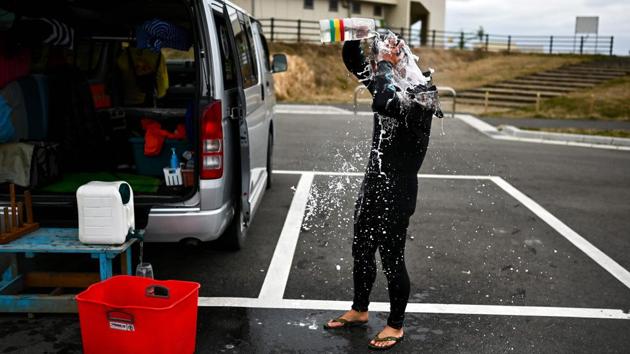 Suzuki washes himself after a surfing session. Nine years later, Prime Minister Shinzo Abe is keen to use the upcoming Tokyo Olympics to showcase Fukushima’s recovery, planning to start the Japan leg of the torch relay from there. Abe’s government also lifted an evacuation order for parts of Futaba, one of two towns hosting the nuclear plant, to allow the torch relay to go through. (Charly Triballeau / AFP) Suzuki washes himself after a surfing session. Nine years later, Prime Minister Shinzo Abe is keen to use the upcoming Tokyo Olympics to showcase Fukushima’s recovery, planning to start the Japan leg of the torch relay from there. Abe’s government also lifted an evacuation order for parts of Futaba, one of two towns hosting the nuclear plant, to allow the torch relay to go through. (Charly Triballeau / AFP)