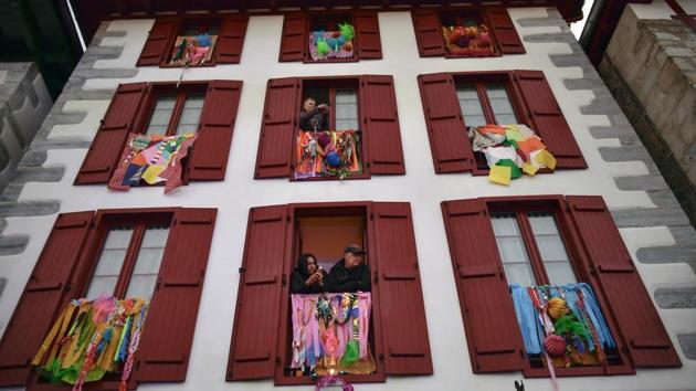 Residents look out from windows of a building as participants dressed as the traditional carnival characters "Zaku Zaharrak" participate in a carnival parade in Lesaka village. Locals parade through the village streets with a giant figure of ‘Miel Otxin,’ which is attached to a wooden structure and represents a legendary bandit. (Alvaro Barrientos / AP) Residents look out from windows of a building as participants dressed as the traditional carnival characters "Zaku Zaharrak" participate in a carnival parade in Lesaka village. Locals parade through the village streets with a giant figure of ‘Miel Otxin,’ which is attached to a wooden structure and represents a legendary bandit. (Alvaro Barrientos / AP)