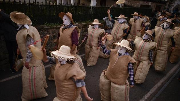 Participants dressed as the traditional carnival characters "Zaku Zaharrak," or old sack, in Basque language, participate in a carnival parade in the small Pyrenean village of Lesaka, northern Spain. After sunset, covering their faces with white handkerchiefs, stuffed into sacks full of straw, and holding a stick with an inflated animal bladder used to hit people, the "Zaku Zaharrak" characters parade for hours through the village dancing and singing while a band plays music. (Alvaro Barrientos / AP) Participants dressed as the traditional carnival characters "Zaku Zaharrak," or old sack, in Basque language, participate in a carnival parade in the small Pyrenean village of Lesaka, northern Spain. After sunset, covering their faces with white handkerchiefs, stuffed into sacks full of straw, and holding a stick with an inflated animal bladder used to hit people, the "Zaku Zaharrak" characters parade for hours through the village dancing and singing while a band plays music. (Alvaro Barrientos / AP)
