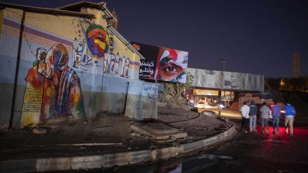 People walk towards the tunnel under a railway track that was at the heart of last years’ sit-in, the epicentre of the revolution in Khartoum, Sudan. On the walls outside the charity centre, a mural with faces of dead protesters reads, “Shame on us if the blood of the martyrs was shed for naught.” (Nariman El-Mofty / AP) People walk towards the tunnel under a railway track that was at the heart of last years’ sit-in, the epicentre of the revolution in Khartoum, Sudan. On the walls outside the charity centre, a mural with faces of dead protesters reads, “Shame on us if the blood of the martyrs was shed for naught.” (Nariman El-Mofty / AP)