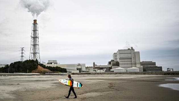 Koji Suzuki, 64, a surfer and a surf shop owner, walks on the beach in front of a thermal power station after a surfing session in Minamisoma, Fukushima prefecture, Japan. Suzuki's local beach, Minamisoma, is around 30 kilometre north of the crippled Fukushima Daiichi nuclear plant and he still has vivid memories of March 11, 2011, when a towering tsunami triggered by a magnitude 9.0 quake surged inland, ravaging the facility. (Charly Triballeau / AFP)