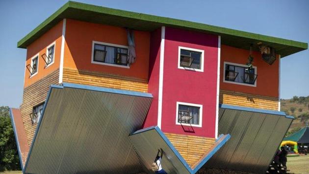 Visitors take pictures of themselves in rooms that have sofas and chairs hanging from the ceiling.(AP Photo)