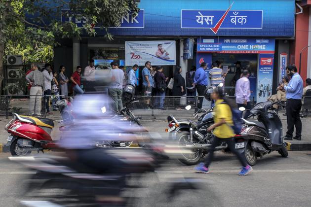 A motorcyclist drive past as customers standing in line outside a Yes Bank Ltd. branch in Mumbai. (Bloomberg) A motorcyclist drive past as customers standing in line outside a Yes Bank Ltd. branch in Mumbai. (Bloomberg)