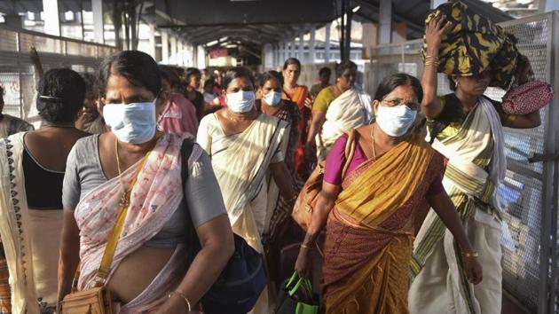 Women devotees wearing masks head to their homes after making offerings during the annual Pongala festival at the Attukal temple in Thiruvananthapuram, on March 9.(AP Photo)
