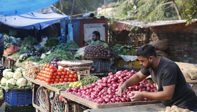 A vegetable vendor awaits customers while arranging onions in his cart at a market. (AP photo) A vegetable vendor awaits customers while arranging onions in his cart at a market. (AP photo)
