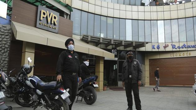Indian private security men wear masks outside a closed movie theatre in India after coronavirus outbreak.(AP photo)