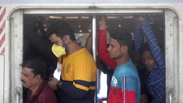 A passenger wearing a face mask as a prevention against Covid-19 travels with others in a local train in Mumbai, on Thursday.(AP Photo)