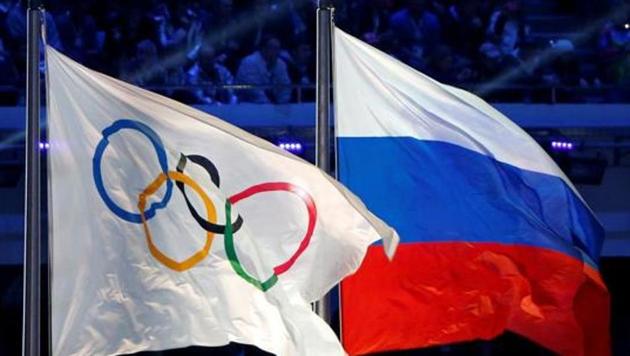 The Russian national flag (R) and the Olympic flag are seen during the closing ceremony for the 2014 Sochi Winter Olympics.(REUTERS)