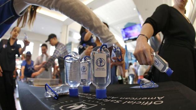 Fans reach for hand sanitizer before an NBA basketball game between the Denver Nuggets and the Dallas Mavericks on Wednesday. (AP Photo) Fans reach for hand sanitizer before an NBA basketball game between the Denver Nuggets and the Dallas Mavericks on Wednesday. (AP Photo)
