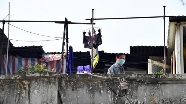 A man wearing a face mask stands on the terrace of a building. Chinese officials and some public health experts have credited the draconian confinement measures on a city of 11 million, and much of Hubei province, of which it is the capital, with slowing the spread of the disease and turning the tide of infection across China. (REUTERS) A man wearing a face mask stands on the terrace of a building. Chinese officials and some public health experts have credited the draconian confinement measures on a city of 11 million, and much of Hubei province, of which it is the capital, with slowing the spread of the disease and turning the tide of infection across China. (REUTERS)
