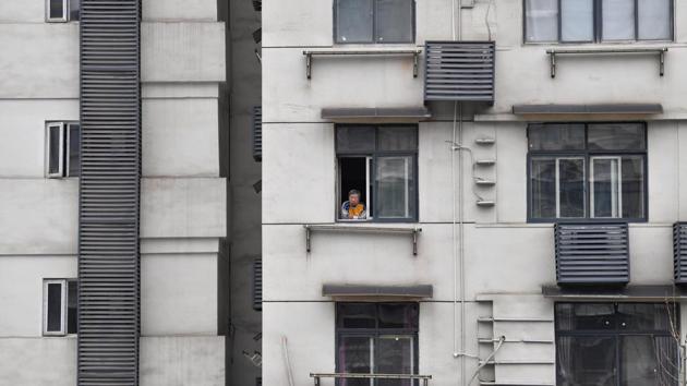 A man looks out of the window of a residential building. Other countries, including Iran, Italy and the United States, are struggling to manage their outbreaks. (REUTERS) A man looks out of the window of a residential building. Other countries, including Iran, Italy and the United States, are struggling to manage their outbreaks. (REUTERS)