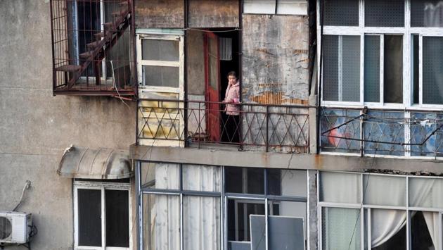 A woman looks outside from the balcony at a residential compound. On Tuesday, Wuhan closed the last of 14 makeshift hospitals set up to treat and isolate patients after the outbreak had overwhelmed the city’s healthcare system. In a dramatic sign that the situation is improving, President Xi Jinping made a high-profile visit to the stricken city on Tuesday, his first since the outbreak began. (REUTERS) A woman looks outside from the balcony at a residential compound. On Tuesday, Wuhan closed the last of 14 makeshift hospitals set up to treat and isolate patients after the outbreak had overwhelmed the city’s healthcare system. In a dramatic sign that the situation is improving, President Xi Jinping made a high-profile visit to the stricken city on Tuesday, his first since the outbreak began. (REUTERS)