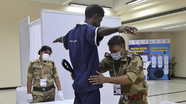 Central Industrial Security Force (CISF) personnel wearing masks as a precaution against the new coronavirus frisk visitors at the Wings India 2020 international exhibition and conference on civil aviation at Begumpet airport in Hyderabad, Thursday, March 12, 2020.(AP)