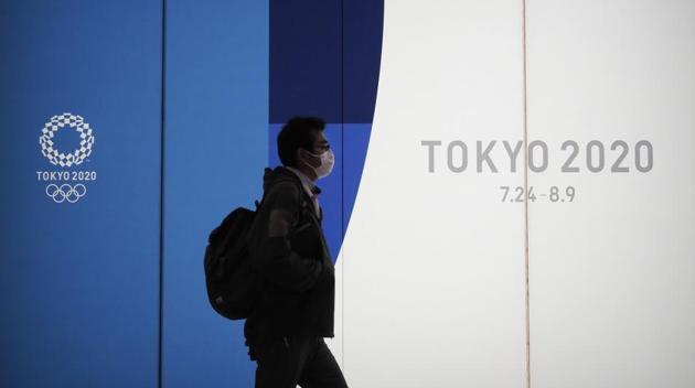 A man walks past a large display promoting the Tokyo 2020 Olympics in Tokyo.(AP) A man walks past a large display promoting the Tokyo 2020 Olympics in Tokyo.(AP)