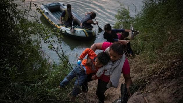 Ladi, a migrant from Honduras, climbs up the bank of the Rio Grande river while holding her 4-year-old nephew Dedier, in Los Ebanos, Texas. Children, many still in diapers, are vulnerable. Smugglers travel back and forth across the Rio Grande transporting their human cargo and will sometimes hold back a child and threaten to throw them in the water if agents get too close, border agents say. (Adrees Latif / REUTERS)