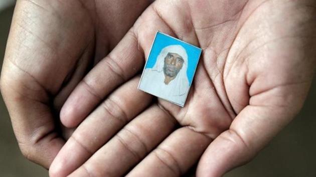 Irshad Khan, 24, holds a picture of his late father Pehlu, 55. (REUTERS) Irshad Khan, 24, holds a picture of his late father Pehlu, 55. (REUTERS)