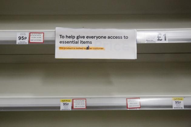A sign reading 'To help give everyone access to essential items' hangs from empty shelves at a Tesco Plc supermarket store in Portsmouth, UK. (Bloomberg) A sign reading 'To help give everyone access to essential items' hangs from empty shelves at a Tesco Plc supermarket store in Portsmouth, UK. (Bloomberg)