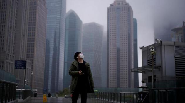 A man wearing a protective face mask is seen following an outbreak of coronavirus (COVID-19), at Lujiazui financial district in Shanghai, China March 13, 2020.(Reuters)