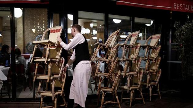 A restaurant employee clears out all the outside seats and prepares the closure of the place, as France's Prime Minister announced to close most all non-indispensable locations, notably cafes, restaurants, cinemas, nightclubs and shops from midnight on Saturday, March 14. (REUTERS) A restaurant employee clears out all the outside seats and prepares the closure of the place, as France's Prime Minister announced to close most all non-indispensable locations, notably cafes, restaurants, cinemas, nightclubs and shops from midnight on Saturday, March 14. (REUTERS)