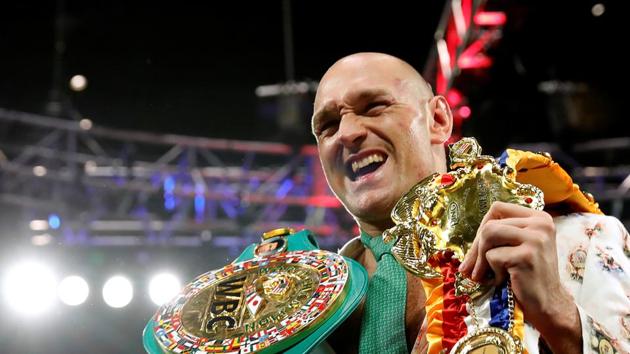 Tyson Fury poses with his belts during a press conference.(REUTERS)