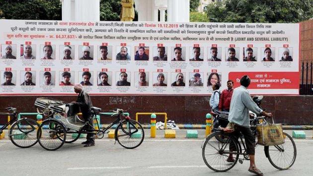 Lucknow administration put up hoardings with photographs, names, and addresses of 57 people who have been issued recovery notice for their alleged involvement in violence during anti CAA protest last December.(ANI)