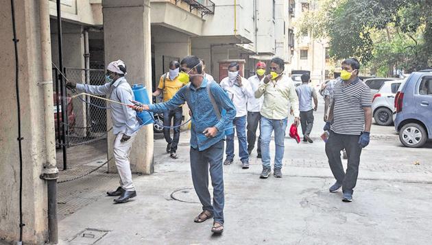 PMC workers spray disinfectant at a housing society on Sinhgad road on Monday. (Pratham Gokhale/HT Photo) PMC workers spray disinfectant at a housing society on Sinhgad road on Monday. (Pratham Gokhale/HT Photo)