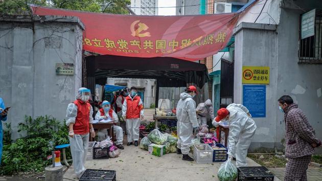 This photo taken on March 16, 2020 shows community volunteers distributing vegetables and foods ordered by residents in China’ Wuhan.(AFP Photo) This photo taken on March 16, 2020 shows community volunteers distributing vegetables and foods ordered by residents in China’ Wuhan.(AFP Photo)